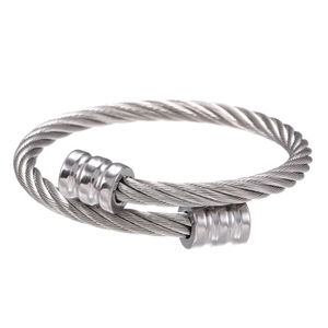 Detailopname van een zilverkleurige gedraaide kabelarmband met gegroefde metalen eindkappen