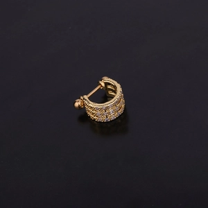 Close-up of golden U-shaped cartilage earring with hollow design and clear cubic zirconia