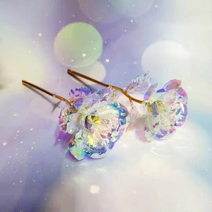 Close-up of iridescent foil roses with golden stems on a dreamy purple background
