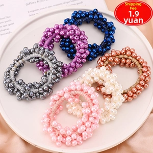 Detail of six assorted pearlescent hair ties in elegant colors displayed on a plate