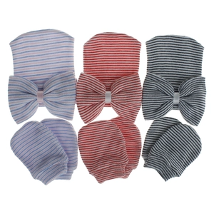 Detalle del conjunto de gorro y mitones a rayas para recién nacido con lazos grandes