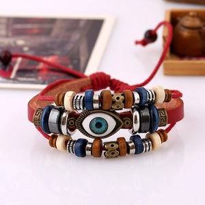 Detailed close-up of a red leather evil eye bracelet with wooden beads and ethnic charms