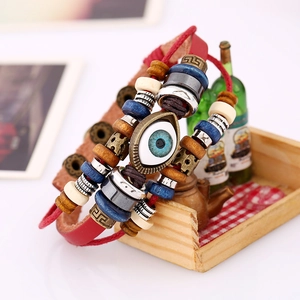 Detail of multi-layer leather bracelet with wooden beads and evil eye charm in a box