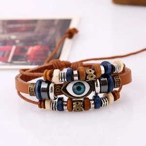 Detail of multi-layer brown leather bracelet featuring evil eye and ethnic wood beads