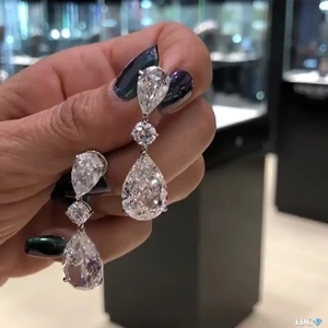 Close-up of silver-plated pear-cut cubic zirconia drop earrings held in hand