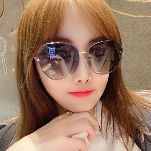 Women's round oversized sunglasses with gold metal temples and black gradient lenses