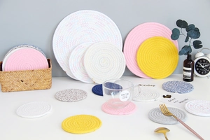 Detailed stack of colorful woven cotton rope coasters and heat resistant dining mats