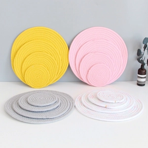 Detail of colorful round woven cotton coasters and table mats stacked by size