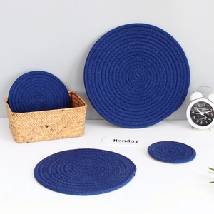 Detail of dark blue round braided cotton coasters set with matching woven storage basket