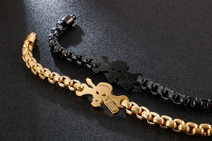 Detail view of industrial skull bracelets with gold and black box chain finish