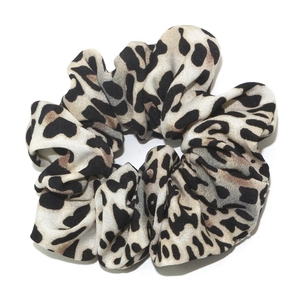 Chic leopard print hair scrunchie with classic beige and black patterns on white background