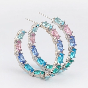 Close-up of silver hoop earrings with marquise-cut gradient gemstones in multiple colors