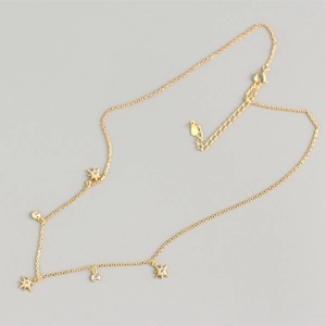 Detailed shot of golden S925 sterling silver necklace with star and round stone charms