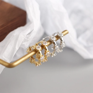 Macro side view of gold and silver S925 sterling silver hoop earrings with cubic zirconia