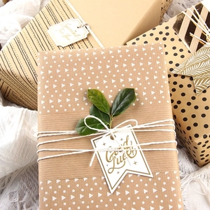 Eco-friendly kraft gift wrapping paper with geometric patterns and decorative tags