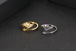 Detail of gothic devil wing open rings in gold and silver finishes with arrow design