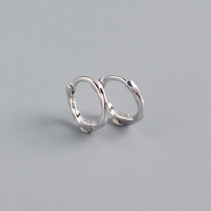 Macro detail of S925 sterling silver hoop earrings with a twisted wire texture design