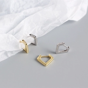 Detail of gold and silver S925 pentagon hoop earrings with sparkling zircon crystals