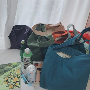 Detail shot of solid canvas tote bags in assorted colors with spacious open design