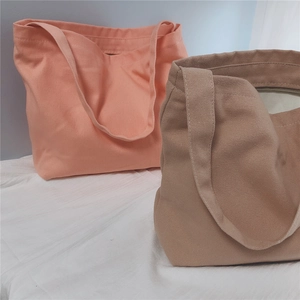 Detail view of pink and khaki canvas tote bags showing spacious interior and zip pocket
