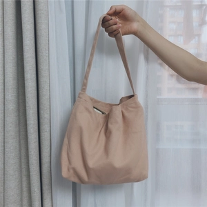 Detailed view of apricot canvas tote bag with reinforced handles and soft cotton texture