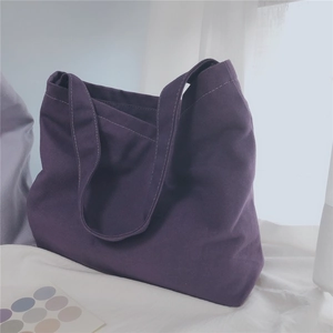 Detail of deep purple canvas tote bag showing thick texture and white stitching details