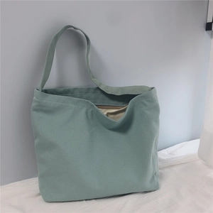 Detailed shot of Morandi green canvas tote bag showing the zipper and fabric texture