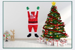 Détail du Père Noël grimpant créatif en velours rouge suspendu au mur blanc pur