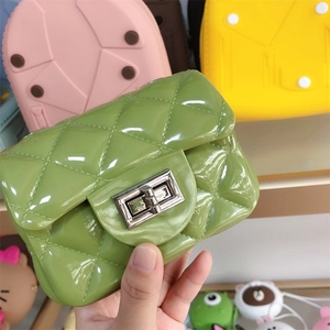 Close-up of green PVC mini jelly bag with quilted texture and gold metal twist lock detail