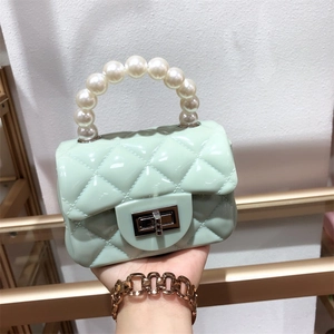 Mini PVC mint green jelly bag with quilted pattern, pearl handle, and metal lock