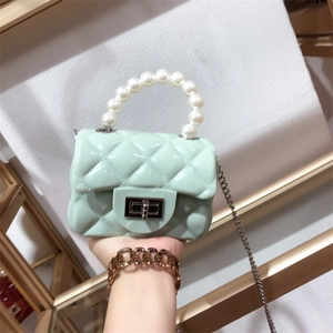 Detail of mini mint green jelly bag featuring pearl handle and diamond quilted pattern
