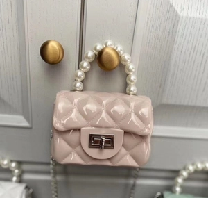 Detail of pink jelly bag showing diamond lattice pattern and elegant pearl handle