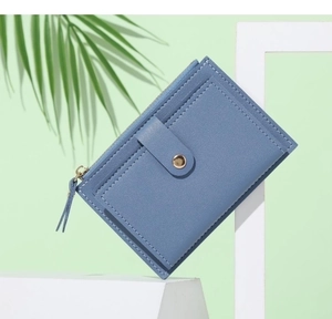 Macro shot of blue PU leather mini wallet with zipper pocket and snap closure detail
