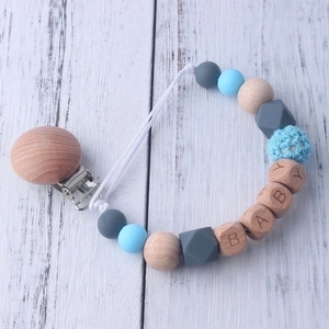 Silicone and beech wood baby pacifier clip chain with BABY letter beads on wood background