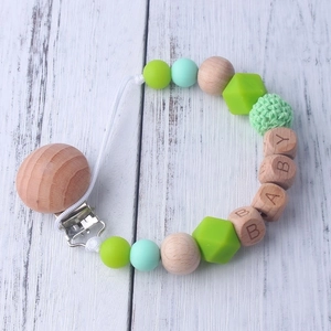 Detail of beech wood and silicone bead pacifier clip with crochet bead and BABY engraving