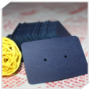 Close-up of small dark blue kraft paper earring display cards with punched holes