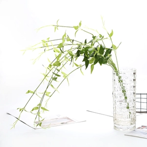 Long artificial clematis hanging plant in a glass vase for home wedding wall decoration
