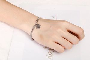 Detailed shot of double-layered stainless steel Hamsa Hand bracelet on a female wrist