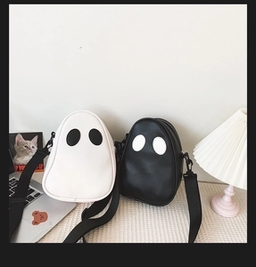 Close-up of contrast eyes on ghost-shaped PU crossbody bags in black and white colors