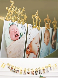 Makroansicht goldener Glitzerstern-Clips und Fotogirlande für den ersten Geburtstag
