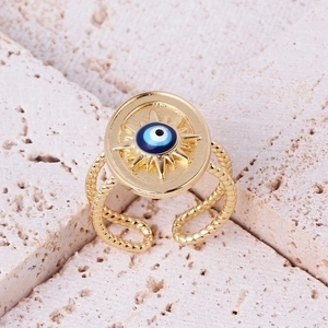 Macro detail of retro sun evil eye ring with blue stones and gold twisted band