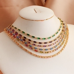 Bohemian multilayer gold necklace with colorful rectangular zircon gemstones on a white bust