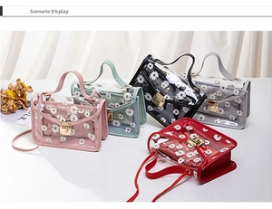 Close-up of transparent PVC crossbody bags with daisy prints in five vibrant colors