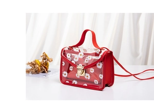 Detail of red floral transparent PVC handbag showing metal lock and inner pouch