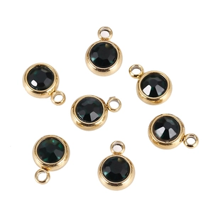 Detailed view of dark green birthstone charms with gold plated settings for jewelry