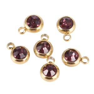 Detailed view of five purple round birthstone charms with gold stainless steel settings