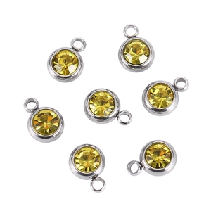 Detailed view of round yellow crystal birthstone pendants with silver stainless steel rings