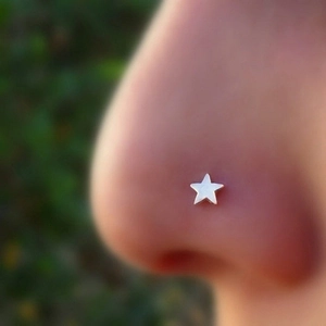 Silver star nose stud made of stainless steel shown as a professional facial piercing