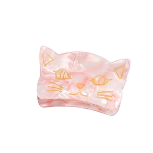 Pink marble acrylic cat hair claw clip with golden facial details on a white background