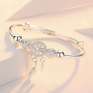 Detailed shot of 999 sterling silver dreamcatcher bracelet with feathers and heart charm